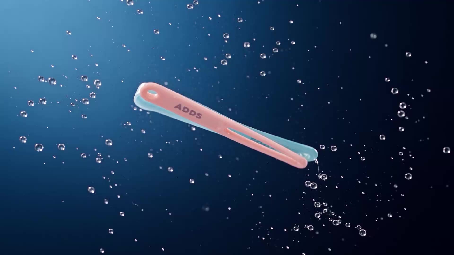 Raspador de língua ADDS TonClean cor salmão, cercado por bolhas de água